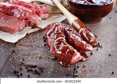 Country Ribs With Barbecue Sauce And Basting Brush Over A Rustic Table. 