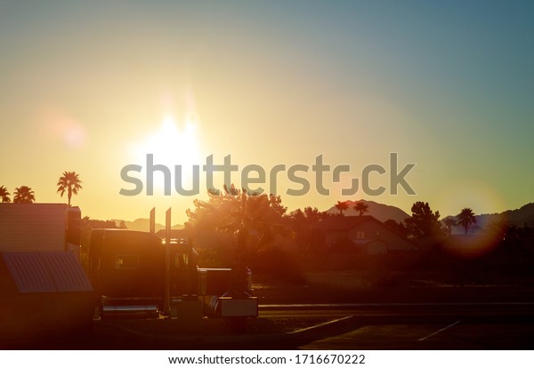 Country road with cloudy sky in the light\
of the dawn sunset on highway sun in truck\
cars