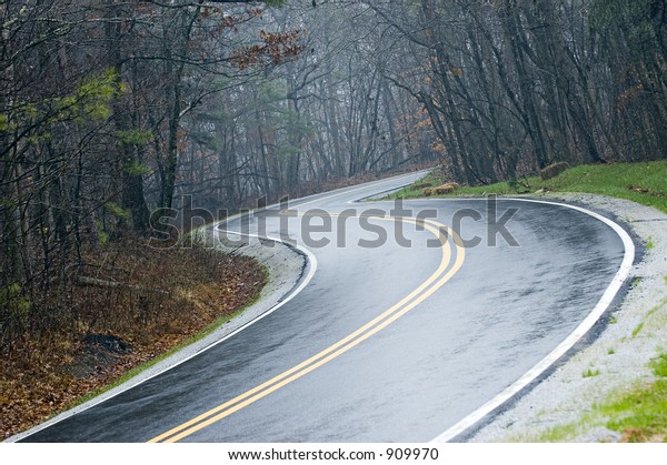 Country road with curves\
after a rain
