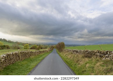 country road farm countryside rural england yorkshire dales view dramatic sky skies dry stone walls sheep farmland animals fields green grass clouds moody seasonal spring walk long distance