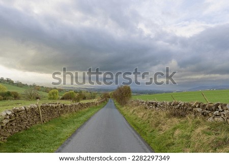 country road farm countryside rural england yorkshire dales view dramatic sky skies dry stone walls sheep farmland animals fields green grass clouds moody seasonal spring walk long distance