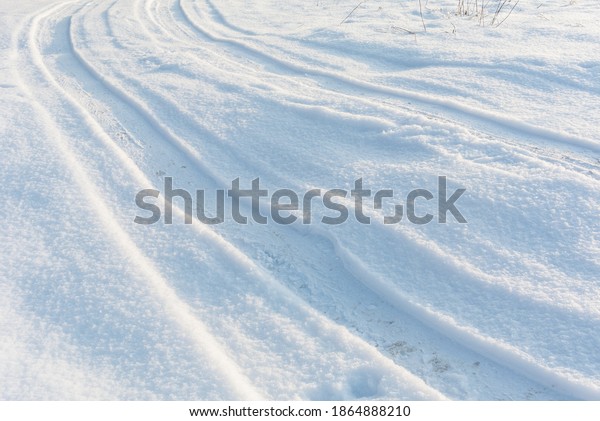 Country road on\
snow field, car tire tracks on white winter snow, perspective view,\
white winter landscape.