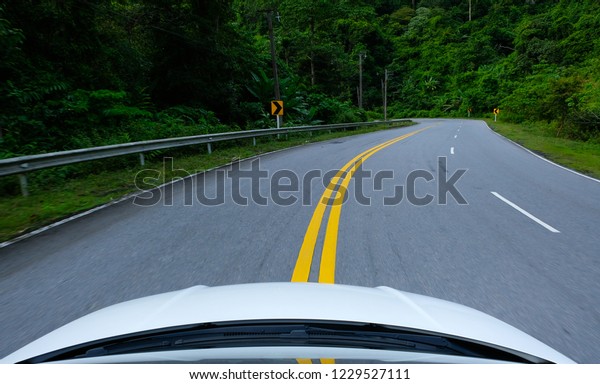 country road and sharp curved on mountain and front\
of car