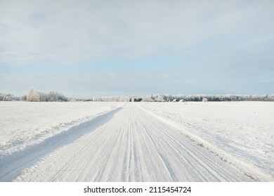 Country road through the snow-covered fields, rural area. View from car. Snow drifts. Europe. Nature, christmas vacations, remote places, winter tires, dangerous driving concept