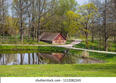 Country scene of stone barn close the lake. Summer daytime