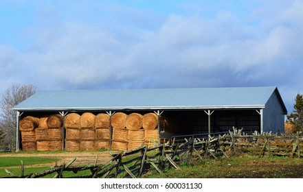 Country Shed With Round Hay Bales In Modern Storage Shed.