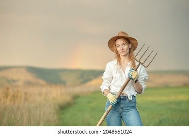 Country Woman In Field With Pitchfork. Harvest Festival