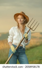 Country Woman In Field With Pitchfork. Harvest Festival