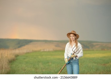 Country Woman In Field With Pitchfork. Harvest Festival