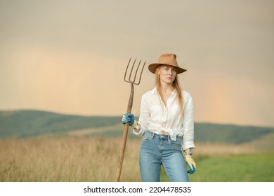 Country Woman In Field With Pitchfork. Harvest Festival