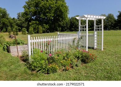 Countryside Flower Garden With White Trellis Arbor And Colorful Blooms