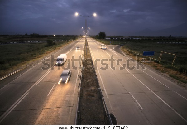 Countryside highway\
at night with several cars.\

