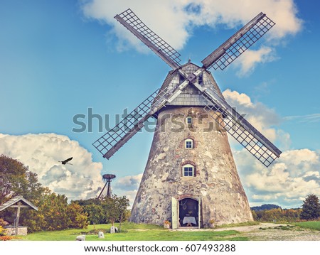 Countryside landscape with old windmill among hills and colorful clouds , Europe