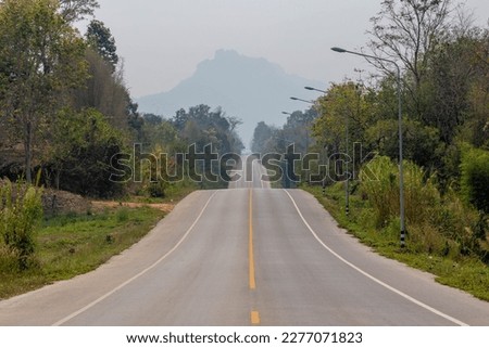 Countryside road up and down on hilly with bad visibility, Smog or dust PM 2.5 (Particulate matter with diameter of less than 2.5 micron) Bad weather and dangerous air pollution in Lampang, Thailand.