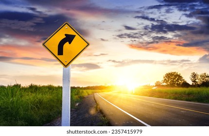 Countryside road ,Sign curved road on the way at the natural Sunset Sunrise Over Field Or Meadow. Countryside Landscape Under Scenic Colorful Sky At Sunset Dawn Sunrise. Warm Colours. - Powered by Shutterstock