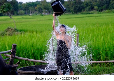 At The Countryside, A Rural Girl Is Taking A Shower From A Traditional Groundwater Source.