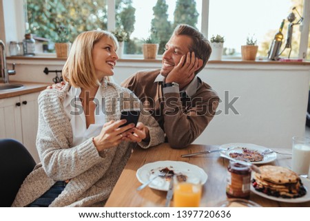 Coupe using technology at the kitchen table