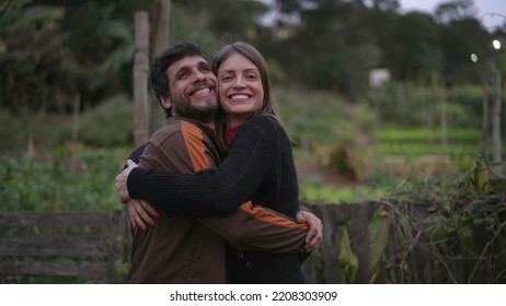 Couple In 30s Embrace Standing Outdoors At Dusk Evening Wearing Sweaters During Cold Night. Friends Hugging Each Other