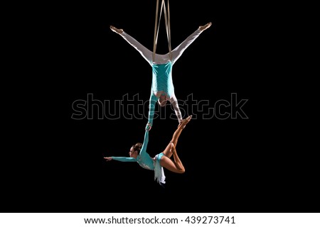 Couple of acrobats perform a trick on slings