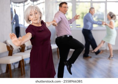 Couple of adult man and elderly woman dancing twist in studio - Powered by Shutterstock