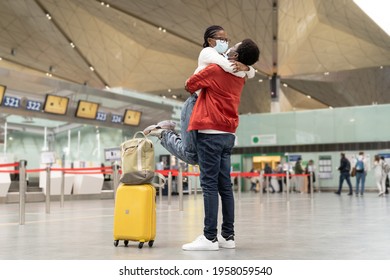 Couple Of African American Tourists In Protective Masks Hug In Airport, Excited Meeting Of Lovers After Covid-19 Pandemic And Lockdown. Welcome Embrace Of Loving Family, Friends After Long Separation