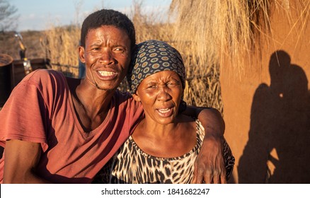 Couple, African Family In Front Of The House With A Thatched Roof, Village In Botswana