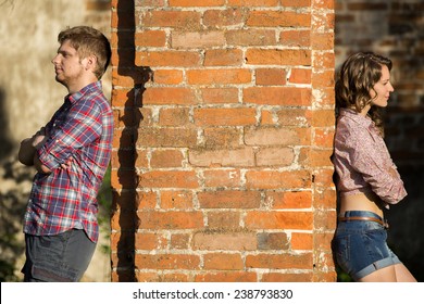 Couple after an argument stands on different sides of the wall