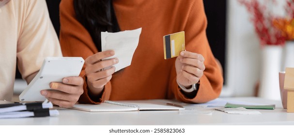 Couple analyzing bills and payment methods, focusing on financial management and budgeting skills.