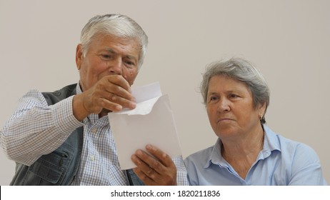 Couple Of Anxious Old Woman And Man Open A Letter, Happy Gift