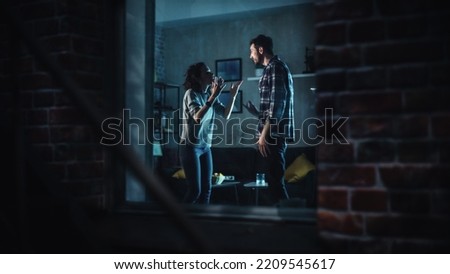Couple Arguing and Fighting Violently. Domestic Violence and Emotional abuse Scene, Stressed Woman and Aggressive Man Screaming at Each other. Dramatic Scene. Shot Through Window Inside Apartment.