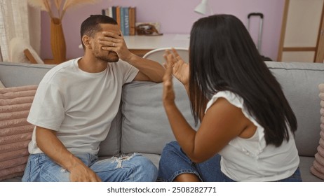 Couple arguing in a living room as a man covers his face with his hand while a woman gestures emotionally, highlighting a strained moment in a domestic setting - Powered by Shutterstock