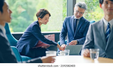 Couple Of Asian Businessperson Meeting In Cafe.