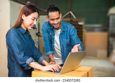 Couple Asian Entrepreneur Work In Stock Or Warehouse Industrial, Businessman And Woman Use Laptop Computer Or Tablet For Check Inventory And Logistic Management.