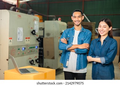 Couple Asian Entrepreneur Work In Stock Or Warehouse Industrial, Businessman And Woman Use Laptop Computer Or Tablet For Check Inventory And Logistic Management.