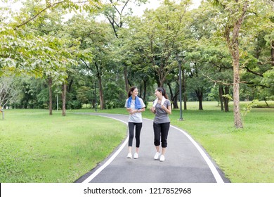 couple asian female running on the way, in public park, they break and resting , health promotion, attractive asian woman exercise and smile - Powered by Shutterstock