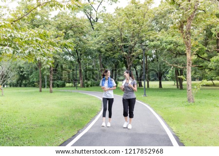 couple asian female running on the way, in public park, they break and resting , health promotion, attractive asian woman exercise and smile