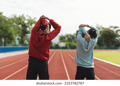 Couple asian jogging and running outdoors at sport stadium warming up stretching before workout. Happy healthy Man woman wearing sportswear jogging. Workout exercise Healthy and lifestyle. - Powered by Shutterstock