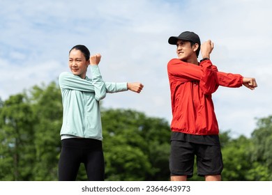 Couple asian jogging and running outdoors at sport stadium warming up stretching before workout. Happy healthy Man woman wearing sportswear jogging. Workout exercise Healthy and lifestyle. - Powered by Shutterstock