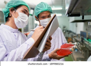 Couple Asian Male Worker Factory Checklist Of Red Juice Buttle Product In Beverage Industry For Quality Assurance Process