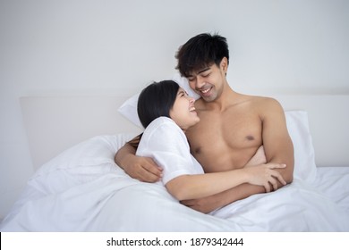 Couple Asian man and woman on bed in white bedroom