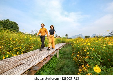 couple asian man and woman with yellow and black wear on beautiful natural field