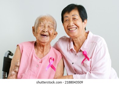 Couple of Asian mother and daughter in pink shirt and pink ribbon for October breast cancer awareness month - Powered by Shutterstock