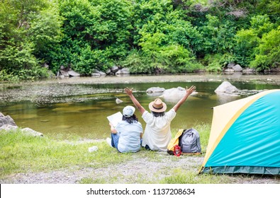 couple asian senior people travel in forest, they camping at lakeside , retirement activity, adventure and travel - Powered by Shutterstock