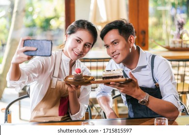 Couple Asian two partner of small business owner taking selfie and presenting the bakery in coffee shop when reccord vlog, Cake and dessert, entrepreneur blogger and startup business concept