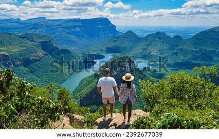 A couple of Asian women and Caucasian men on vacation in South Africa visit the Panorama Route South Africa, the Blyde River canyon with the three rondavels