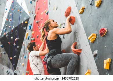 couple of athletes climber moving up on steep rock, climbing on artificial wall indoors. Extreme sports and bouldering concept - Powered by Shutterstock