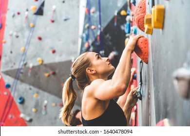 couple of athletes climber moving up on steep rock, climbing on artificial wall indoors. Extreme sports and bouldering concept - Shutterstock ID 1640478094