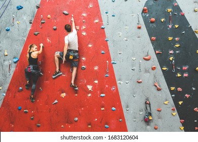 couple of athletes climber moving up on steep rock, climbing on artificial wall indoors. Extreme sports and bouldering concept - Powered by Shutterstock