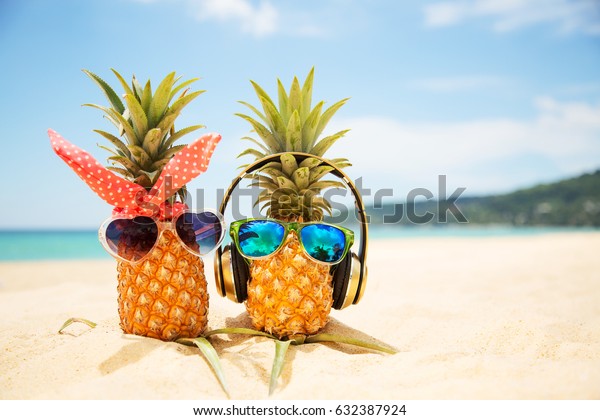 ターコイズ海の砂の上に 魅力的なパイナップルが2 3匹 スタイリッシュなミラーサングラスをかけた 熱帯の夏休みのコンセプト 熱帯の島の浜辺の晴れた日 ハネムーン の写真素材 今すぐ編集