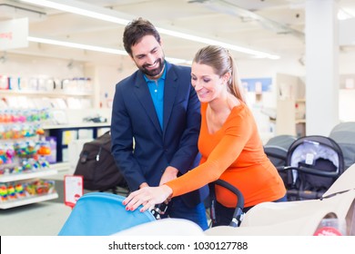 Couple In Baby Shop Buying Stroller, The Woman In Pregnant